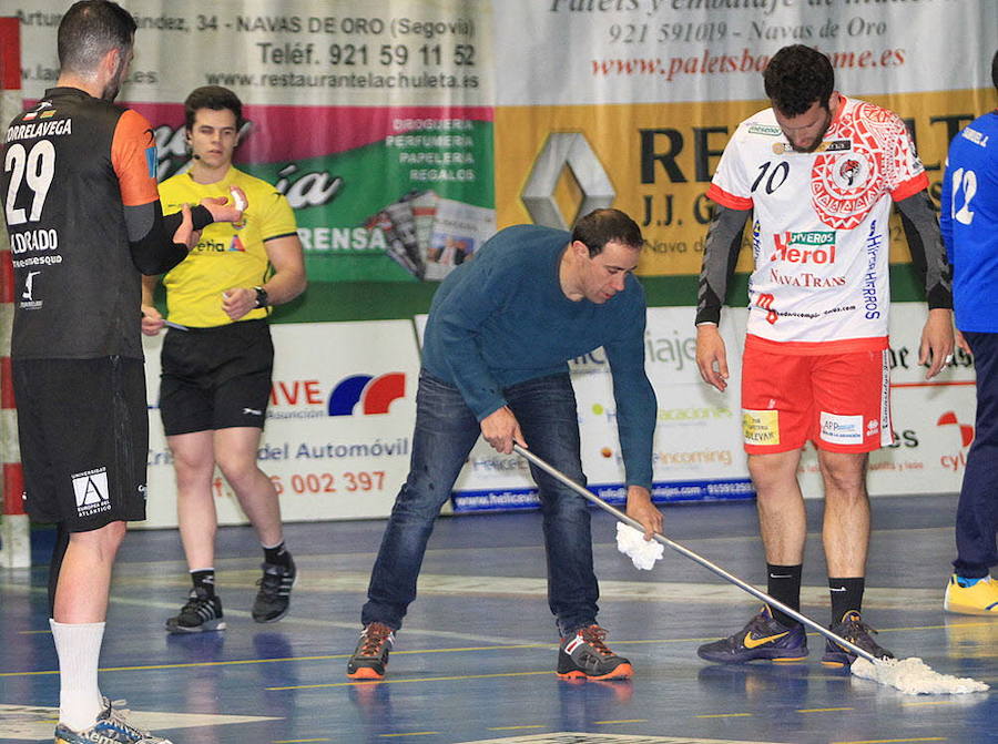 El directivo del Balonmano Nava, Cecilio Ajo, trata de limpiar una gotera del pabellón navero.