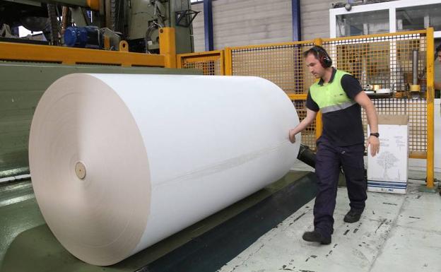 Un operario, junto a una bobina de papel estucado en la planta de Europac de Dueñas.