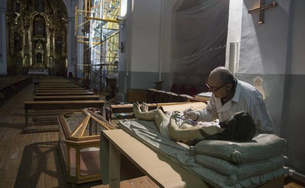 Javier Fraile restaura la figura del Cristo Yacente del retablo. 