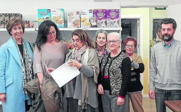 Pilar Sanz (i) y Pilar Gómez escuchan las explicaciones de Rosario Díez sobre los dos servicios en presencia de un grupo de voluntarios. 