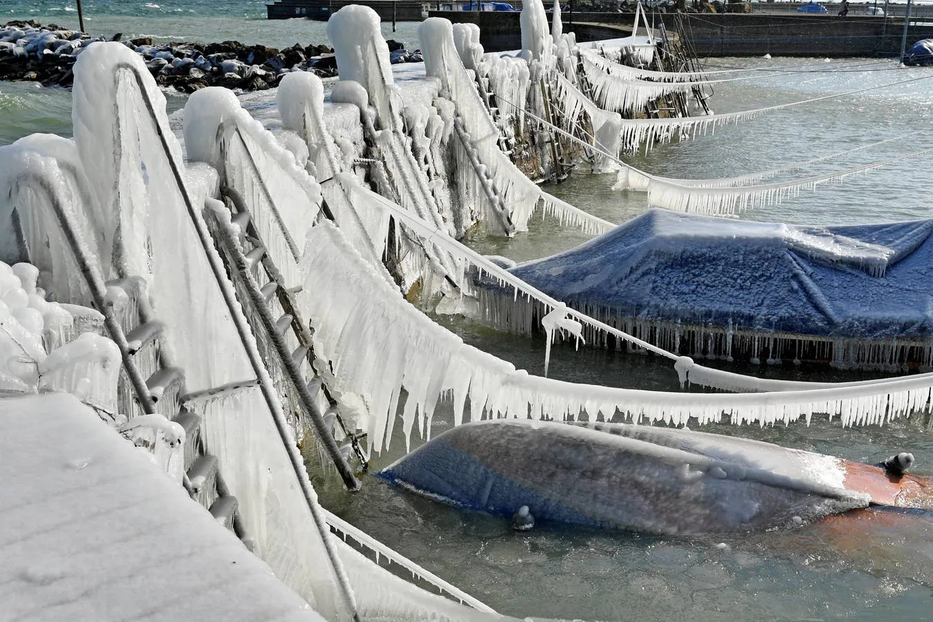 Carámbanos de hielo cubren los amarres de los barcos en el lago de Constanza, en Suiza.
