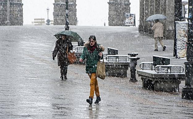 Una joven transita por la avenida del Acueducto entre la nevada de este martes por la tarde en Segovia. 