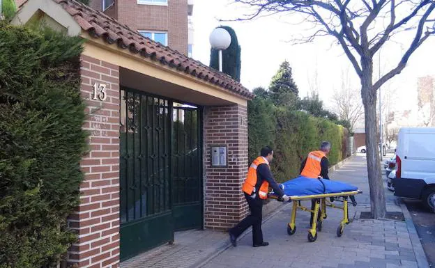 Los operarios del Servicio Forense trasladan el cuerpo de la fallecida del portal del número 15 de la calle Federico Landrove Moiño, en Valladolid.
