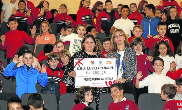 Alumnos del CRA La Villa, de Peñafiel, posan en el momento de la entrega del cheque a la directora de comunicación de Aladina.