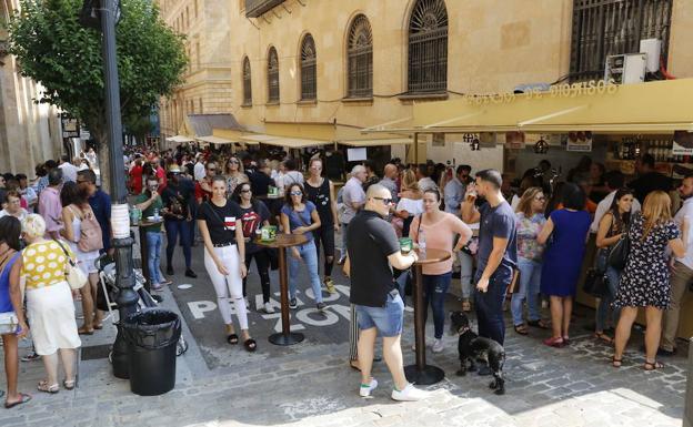 El público disfruta de las tapas de la Feria de Día conversando distendidamente al lado de las casetas. 