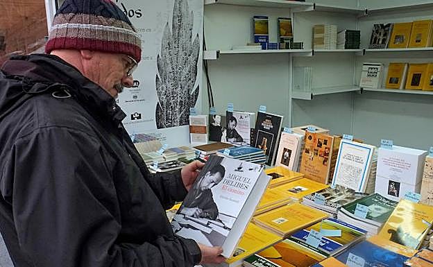 Un hombre observa los libros del puesto de Alvacal, la Asociación de Libreros de Viejo y de Antiguo de Castilla y León. 
