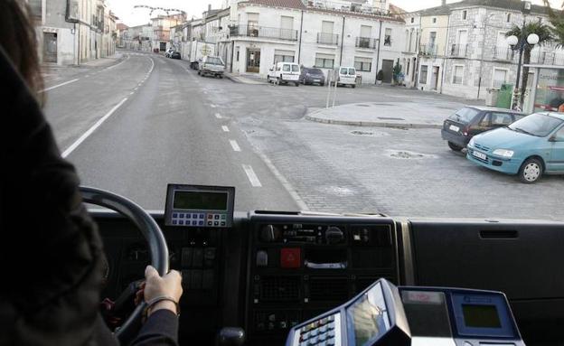 Un autobús llega a la parada de un pueblo. 