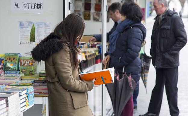 Una joven revisa uno de los libros de la feria. 