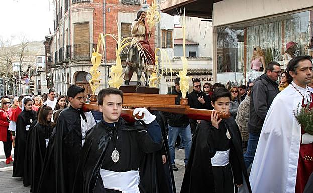 Cuatro niños cofrades portan la imagen de La Borriquilla, ayer en Cuéllar. 
