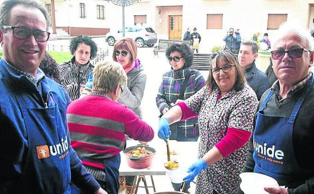 Vecinas de Alcazarén reparten el guiso de patatas.