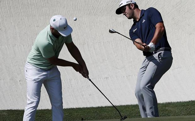 Jon Rahm golpea la bola junto al sueco Alex Noren durante el entrenamiento de ayer.