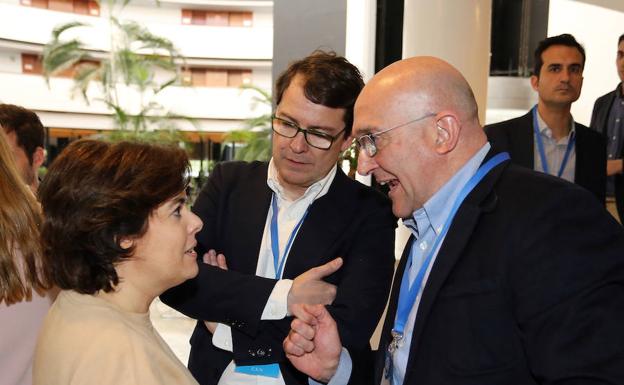 Soraya Sáenz de Santamaría, Alfonso Fernández Mañueco, y Jesús Julio Carnero conversan durante la Convención Nacional del partido en Sevilla.