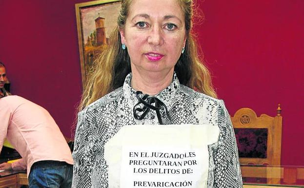 La exalcaldesa, con el cartel alusivo a los procesos judiciales. 