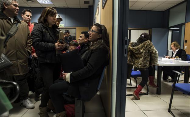 Varias personas esperan para realizar el acto de jura de la Constitución para obtener la nacionalidad española.