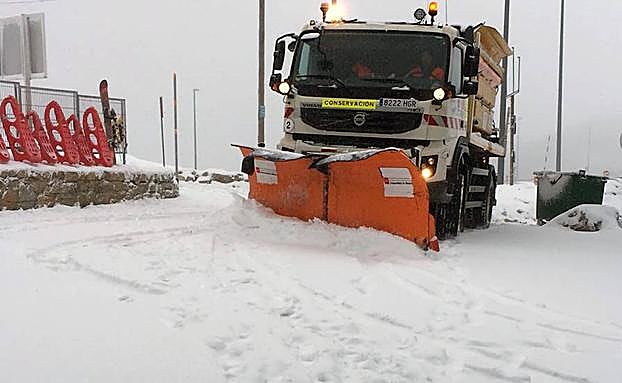 Una máquina limpia la acumulación de nieve en el alto de Navacerrada, este lunes por la mañana. 