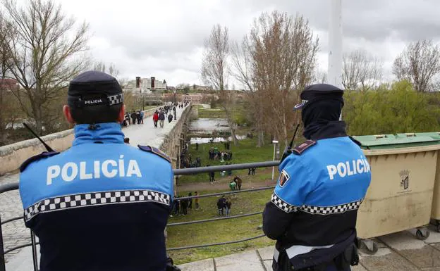 Dos agentes de la Policía Local vigilan al escaso grupo de personas que celebraban ayer el Lunes de Aguas a mediodía. 