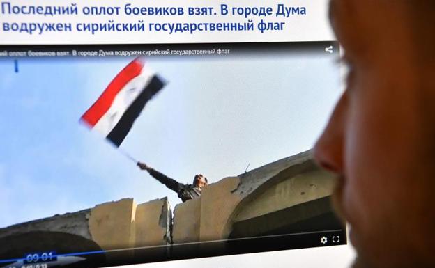 Espectador ruso observa la imagen de la bandera siria en Duma.
