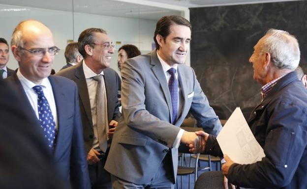 El consejero Juan Carlos Suárez-Quiñones saludando a uno de los representantes municipales. 