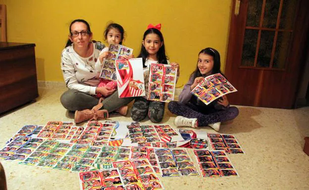 María, con sus hijas Sofía, María y Rocío y los más de 250 cromos que ha confeccionado.