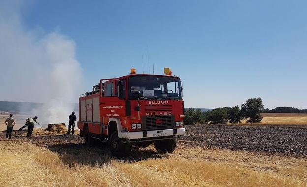 Bomberos voluntarios apagan el fuego en una tierra.