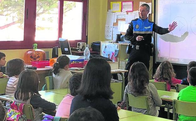 Uno de los agentes de la Policía Local explica las señales de tráfico a los alumnos. 