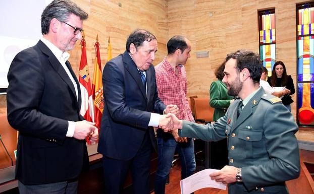 El consejero de Sanidad entrega un diploma a un agente de la Guardia Civil, ayer, en presencia del alcalde de San Ildefonso, José Luis Vázquez. 