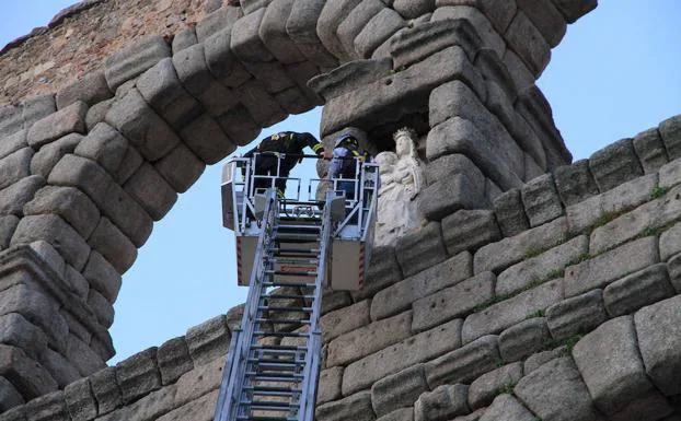 Un bombero revisa la Virgen tras el desprendimiento. 