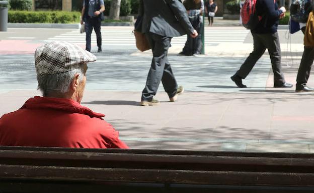 Una persona mayor descansa en un banco del Paseo de Zorrilla. 