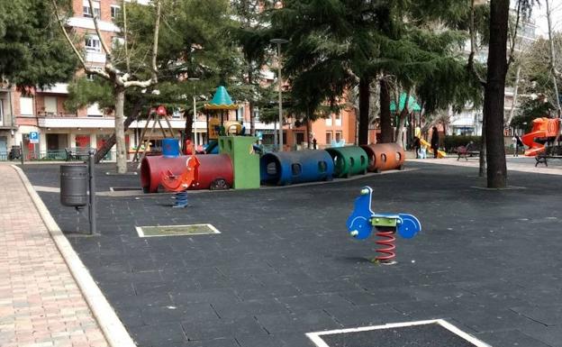 Parque infantil con los alcorques para árboles tapados con materiales plásticos. 