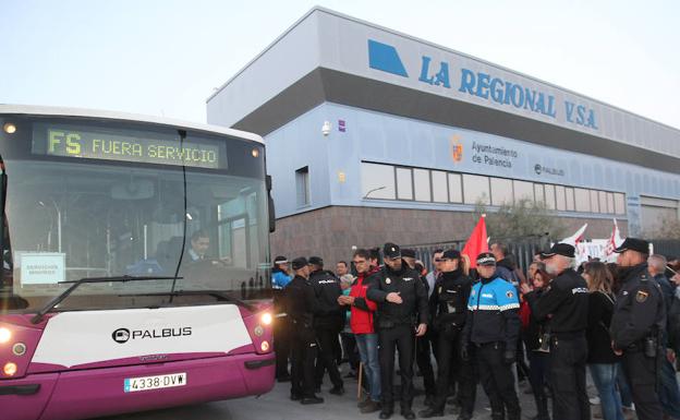 La Policía hace un cordón para permitir el paso de uno de los autobuses.