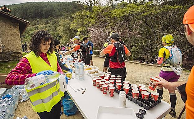 Una voluntaria reparte líquido entre los participantes. 
