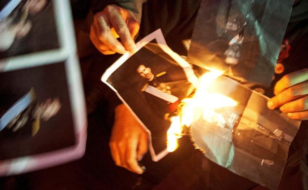 Un grupo de manifestantes quema una foto de Felipe VI.