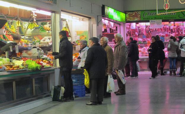 Un grupo de personas hace la compra en el mercado.