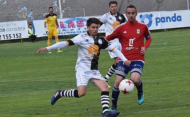 Carlos López pelea un balón con un rival del Ávila. 