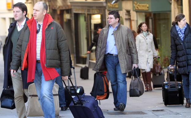 Turistas con sus maletas por una calle de Segovia. 
