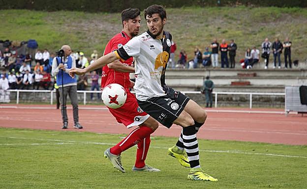Carlos de la Nava y Coque pugnan por un balón durante el pasado derbi en Las Pistas. 