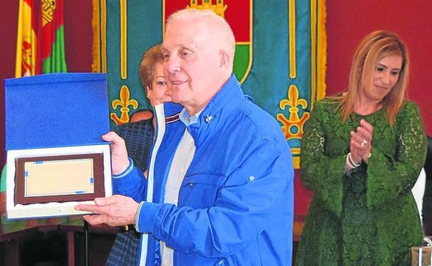 Miguel Gallego muestra la placa de recuerdo del Ayuntamiento.