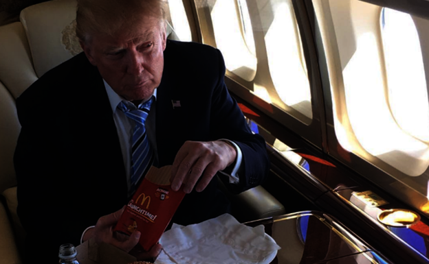 Donald Trump almuerza una hamburguesa con una patatas fritas. 