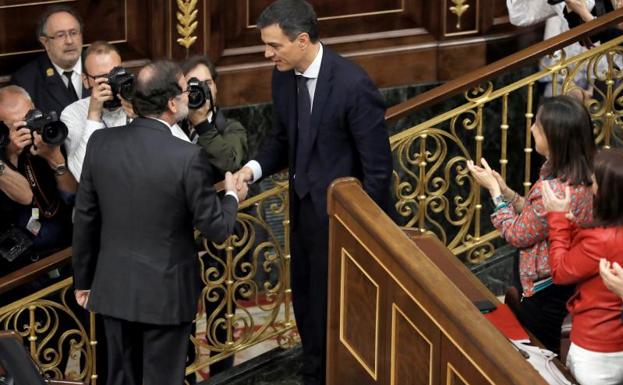 Imagen principal - Arriba, Rajoy y Sánchez se estrechan la mano. Debajo, Sánchez felicitado por los suyos y ya fotografiado en solitario como presidente del Gobierno. 