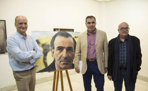 Desde la izquierda, Gustavo Martín Garzo, Manuel Ferro y Miguel Casado, junto al retrato de Ullán. 