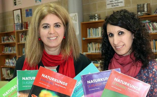 Luisa Arias y Silvia Saballs posan con sus libros de texto de 'Naturkunde'.