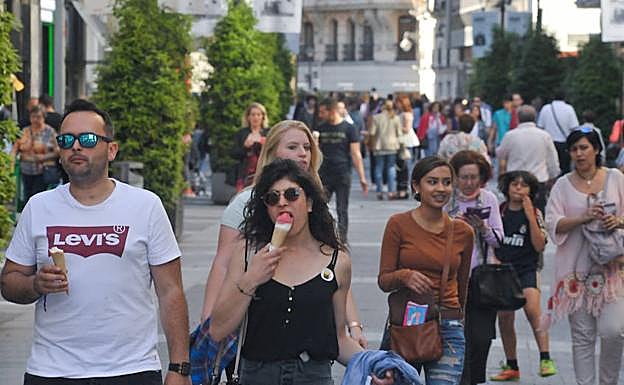 Grupos de personas pasean por la calle Santiago. 