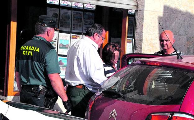 La mujer, tras asistir al registro de su agencia de viajes, entrando en el coche de la Guardia Civil .