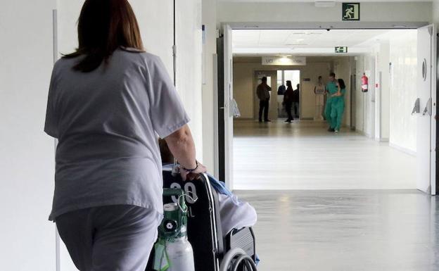 Una enfermera empuja una silla de ruedas. 