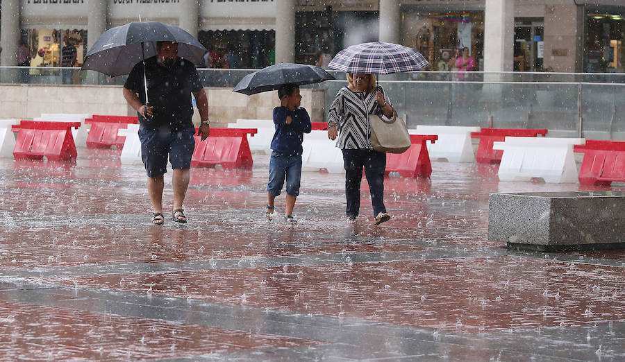 Imagen principal - A la izquierda, una tormenta inesperada en Valladolid. Arriba, a la derecha, una tormenta de granizo en la zona de Herrera de Pisuerga que anegó tierras de cultivo. Debajo, la carretera A-67 colapsada por las fuertes lluvias. 