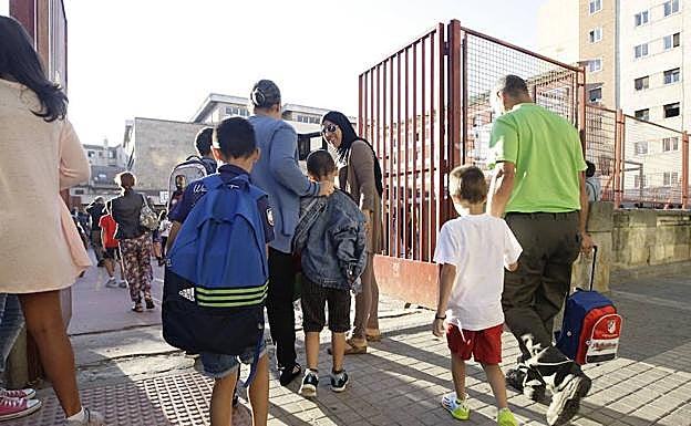 Varios escolares se encaminan hacia las aulas, acompañados por sus padres, en un colegio de la capital salmantina. 