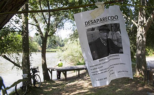Cartel con la imagen del desaparecido colgado en la ribera del Pisuerga, en La Rondilla. 