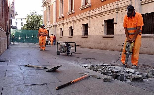 Los operarios pican los adoquines levantados en la calzada de la calle Jesús.