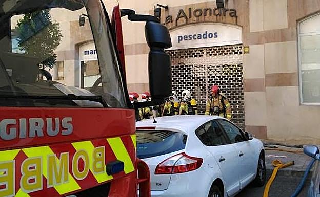 Imagen principal - Los Bomberos de Valladolid sofocan un incendio en el interior de una pescadería de Parquesol
