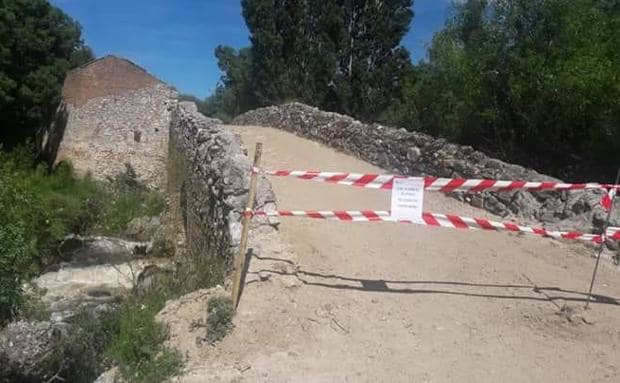 Precinto que impide el paso por el viejo puente de El Naranjo, en Martín Muñoz de las Posadas. 